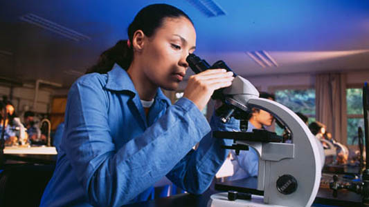 Mulher trabalhando no microscópio
